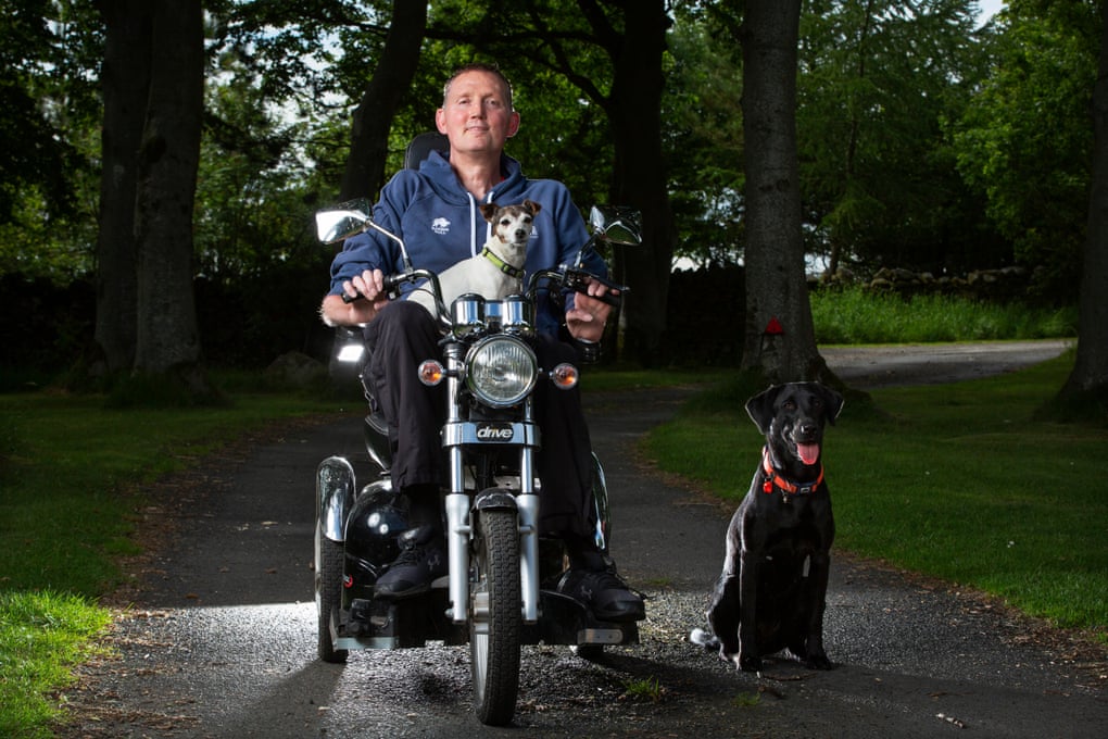 Doddie Weir, with Mavis on his lap and Xena alongside his mobility scooter