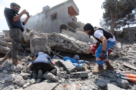 Rescue workers and residents search for survivors after an Israeli airstrike on Deir al-Zahrani in southern Lebanon.