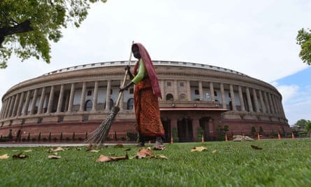A worker cleans the lawn at Parliament House.