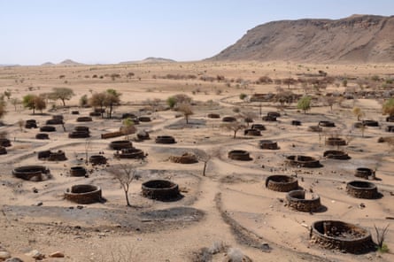 Aerial view of round houses that have been burned, in a desert landscape