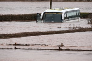 An empty coach sits abandoned in flood water after the River Teme burst its banks near Lindridge.