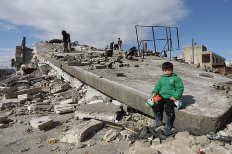 A Syrian child sits on a collapsed building in the town of Azaz on the border with Turkey.