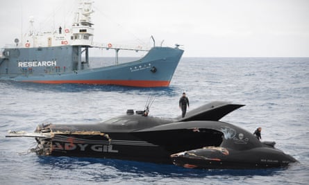 A damaged speed boat that resembles a stealth bomber, with a Japanese whaling ship behind it.