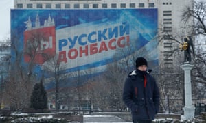 A view shows the rebel-held city of Donetsk<br>A pedestrian walks in a square near a banner displaying the slogan "We are Russian Donbass!" in the rebel-held city of Donetsk, Ukraine January 24, 2022. REUTERS/Alexander Ermochenko