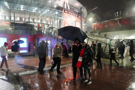 Fans braving the rain outside the ground before the Arsenal v Liverpool Premier League match at Emirates Stadium.