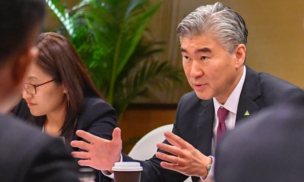 Sung Kim talks with members of the North Korean delegation during a working group meeting before the summit.