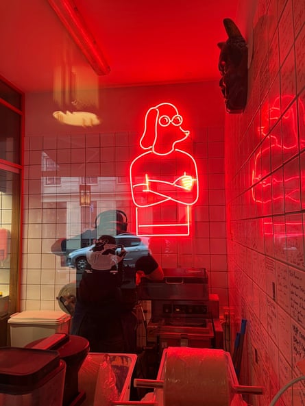 A neon sign of Slurp’s cartoon dog logo inside the restaurant.