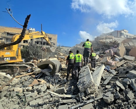 Lebanese civil defence workers search through the rubble of a building in Tyre.