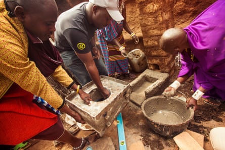Masai people prepare a stove inside a traditional dwelling