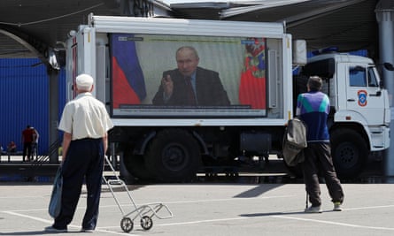Russian president Vladimir Putin on a screen broadcasting Russian TV news in Mariupol.