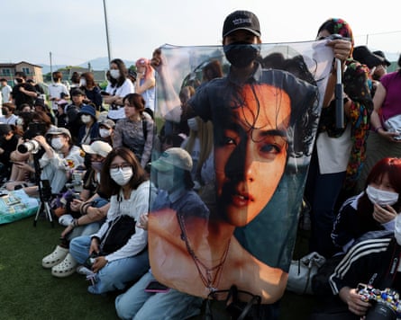 An Indonesian fan holds a photo of BTS member V as fans gather to welcome RM and V after the completion of their 18-month mandatory military service in Chuncheon City