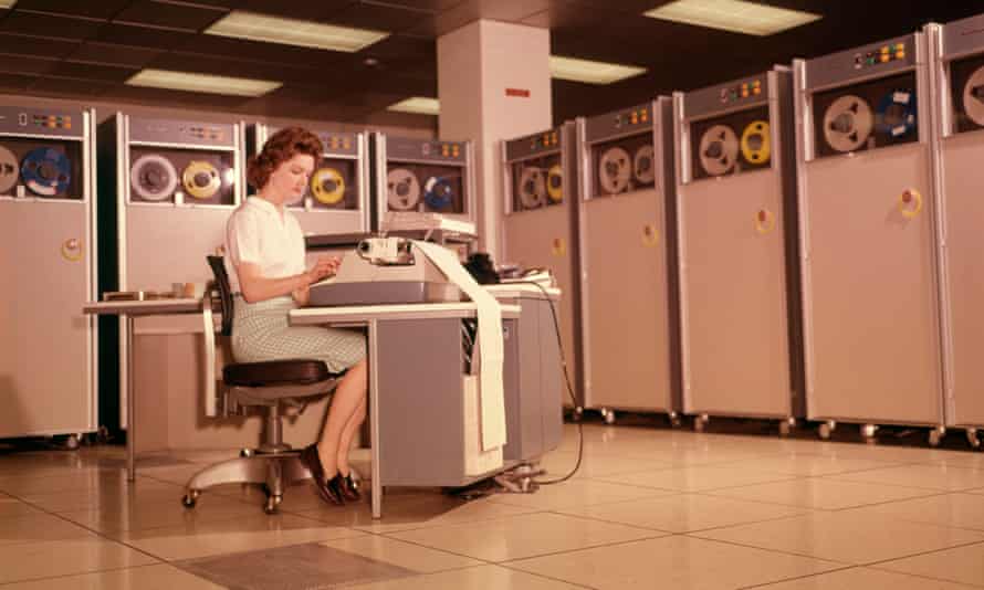 A woman uses a computer in the 1960s.