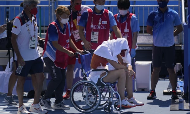 Paula Badosa, of Spain, is helped off the court in a wheelchair having suffered heat exhuastion.