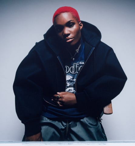 A woman with red hair and a black jacket.