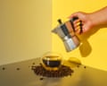 Female hand with a coffee maker and a cup of coffee. Background with food. Coffee drink.