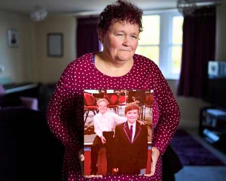 Claire Throssell in her living room holding a large photo of her sons