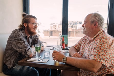Two men facing each other across a restaurant table