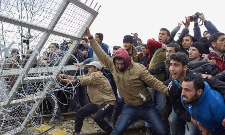 Refugees break the fence on Greek-Macedonia border.