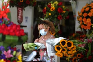 A flower seller waits for customers on the first day of the reopening of Los Angeles flower market.