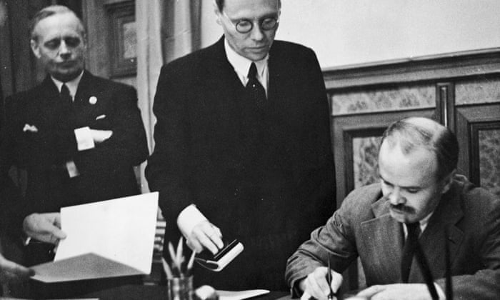 Soviet foreign minister Vyacheslav Mikhailovich Molotov signs the Soviet-German Non-Aggression Pact in Moscow, 23 August 1939. On the left is German foreign minister Joachim von Ribbentrop