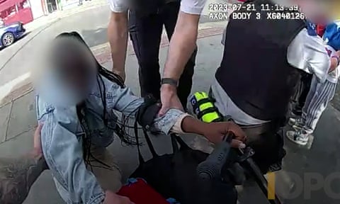 Bodycam footage of male hands on women's arms – her face is blurred out