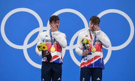 Team GB’s Tom Daley and Matty Lee wipe tears away from their eyes after receiving their gold medals.