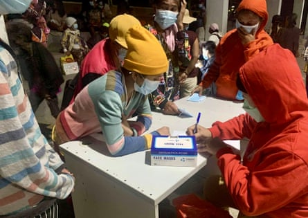 People take shelter inside a school building after the eruption of Kanlaon volcano