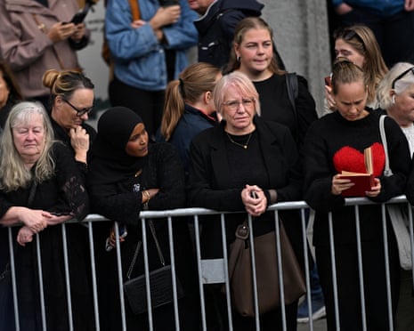 People stand next to a barrier on a street, ahead of the funeral of Norway’s King Harald at Oslo Cathedral, in Oslo, Norway.
