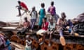 Children sit and play on the remains of a tank, at the river port in Renk, South Sudan