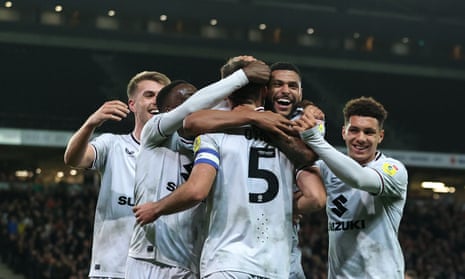 Warren O'Hora of Milton Keynes Dons celebrates with team-mates after scoring their team's first goal against Morecambe.