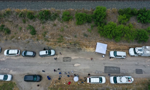 Overhead shot of a rural road where police vehicles are investigating the scene.