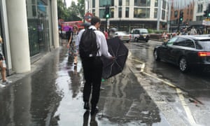 People shelter from the rain in London on Friday.