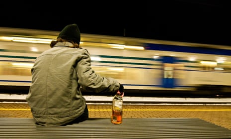 Man on a bench with half empty whisky bottle