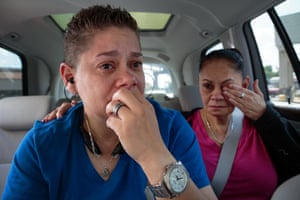 Two women sit in a car, both tearful