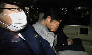 Takahiro Shiraishi covers his face as he is transported to the prosecutor’s office from a police station in Tokyo on Wednesday