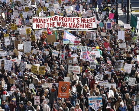 People hold signs and flags as they march during the No Kings national day of protest in Chicago.