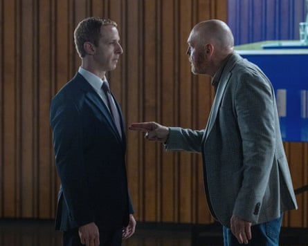 film still – A man jabs his fingers aggressively towards Mark Zuckerberg (played by Jeremy Strong)