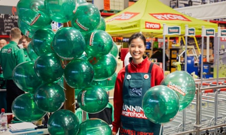 A woman welcoems customers to Bunnings DIY in St Albans with green balloons