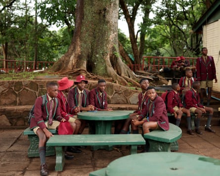 Local children watch an ICC Under-19 Cricket World Cup warm-up match between Scotland and Bangladesh in Harare, Zimbabwe.