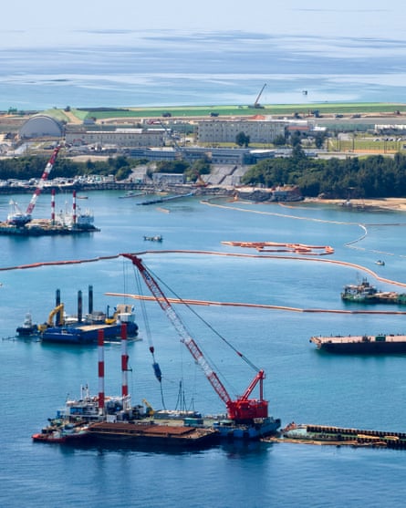 Elevated view of construction ships including floating cranes in a harbour crisscrossed with floating booms