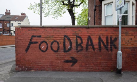 A red brick wall with FOODBANK and an arrow covering it