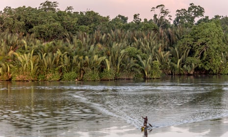 A man and a child paddle in a canoe on the Sepik River in the northern Papua New Guinea.