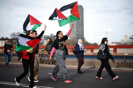 Pro-Palestinian activists and supporters wave flags and carry placards on a march through London, during a National Day of Action for Palestine on Saturday.