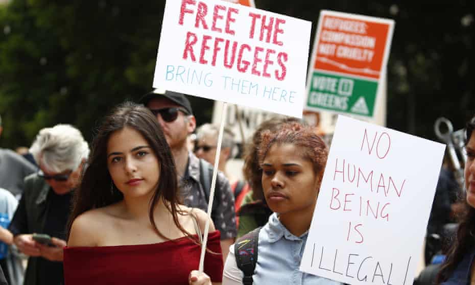 Two woman hold placards at a Sydney rally in support of Manus Island refugees. The Australian Medical Association wants doctors to be allowed to help.