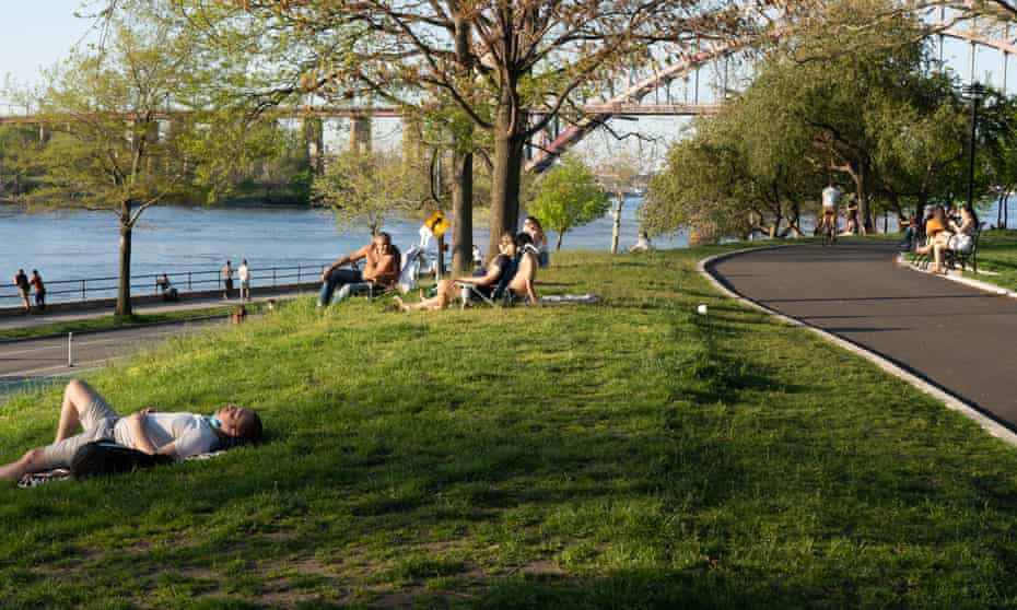 People enjoy the afternoon sun on Sunday at the Astoria Park as temperatures rose amid the coronavirus pandemic in New York City.