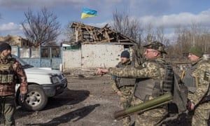 Ukrainian servicemen stand in the village of Lukyanivka outside Kyiv.