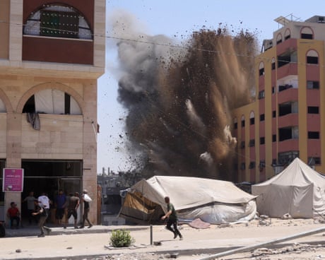 People run away from an exploding building in Gaza City