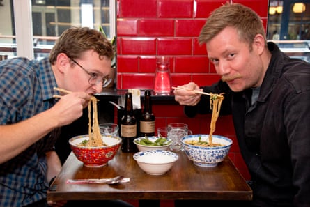 Joe and Stuart eat noodles at the restaurant table