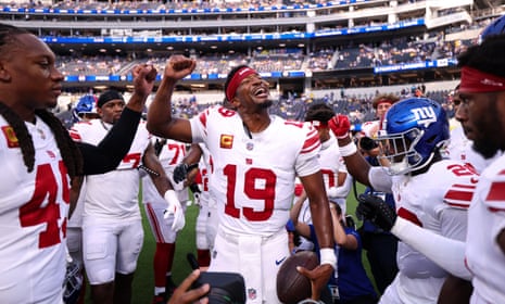Jameis Winston cheers with a raised fist among his Giants teammates on the field