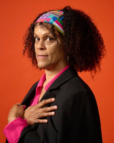 A headshot of Bernardine Evaristo, photographed against an orange background.